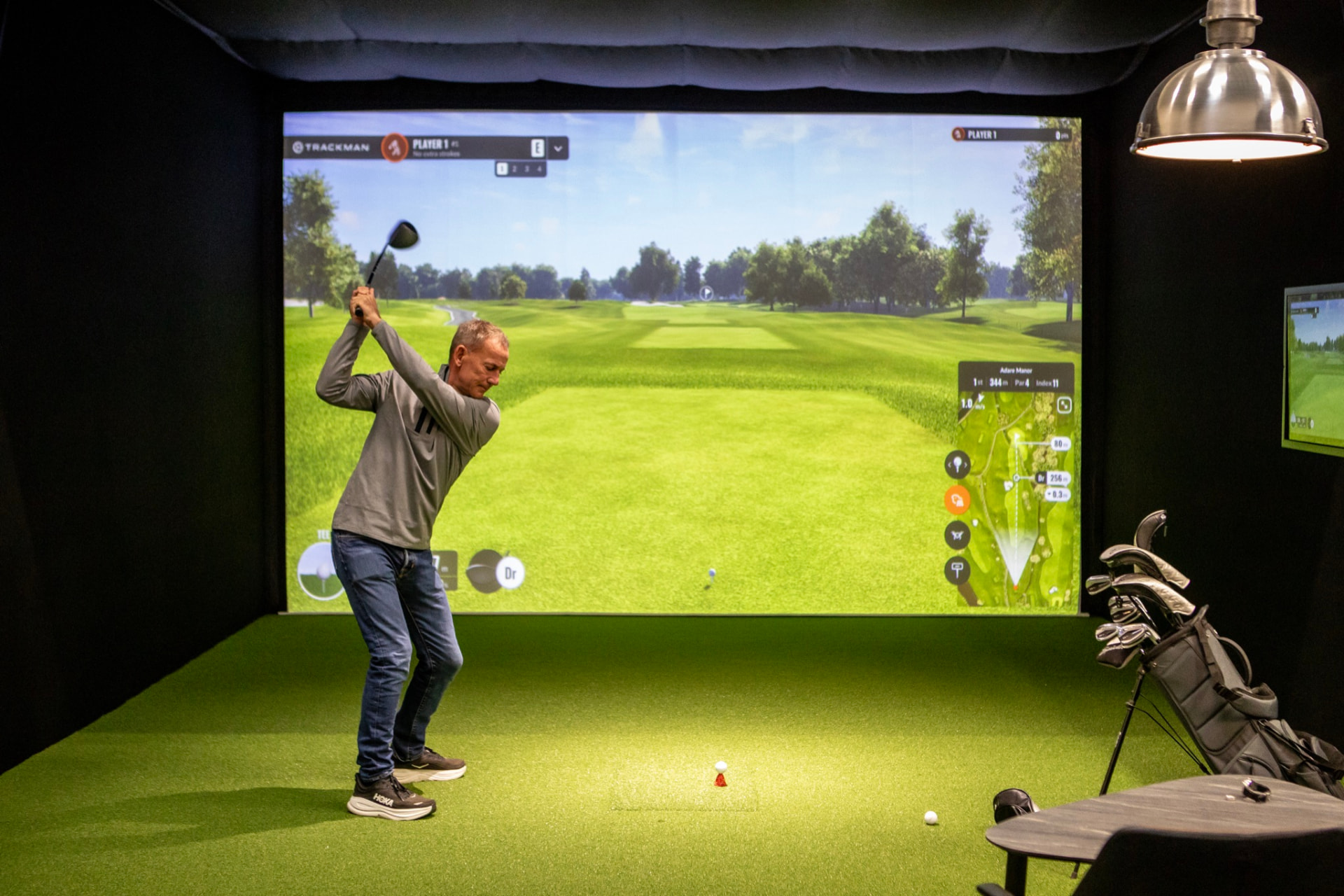 Golfspiller i en simulatorboks med Trackman iO